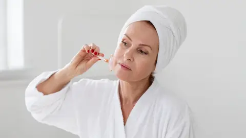 Mujer haciéndose su rutina de cuidado facial Mujer haciéndose su rutina de cuidado facial