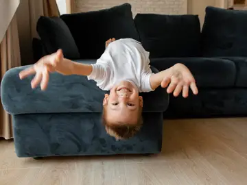 Un niño jugando en el sofá Un niño jugando en el sofá