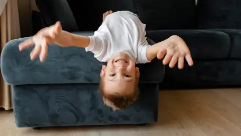 Un niño jugando en el sofá Un niño jugando en el sofá