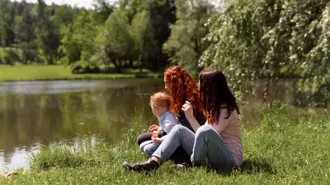 Dos amigas en el parque con un bebé Dos amigas en el parque con un bebé