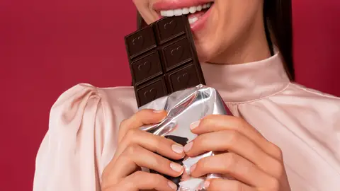 Una mujer comiendo una tableta de chocolate Una mujer comiendo una tableta de chocolate