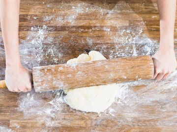 Persona amasando una masa de pizza