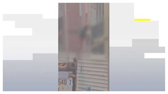 Un okupa col&aacute;ndose en un edificio
