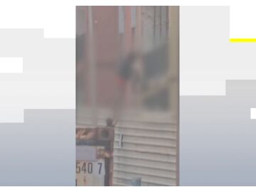 Un okupa colándose en un edificio