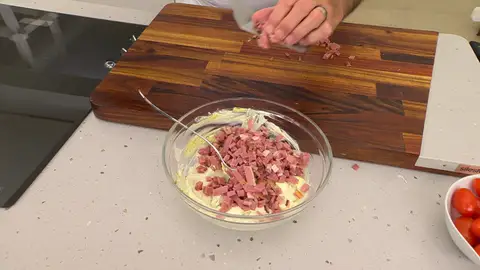 Corta las lonchas de pastrami en daditos, añádelas al bol y mezcla bien Corta las lonchas de pastrami en daditos, añádelas al bol y mezcla bien