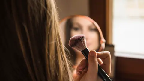 Mujer maquillándose Mujer maquillándose