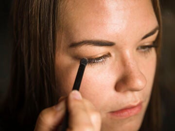 Mujer maquill&aacute;ndose la sombra de ojos