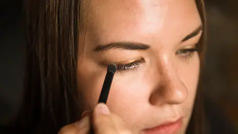 Mujer maquillándose la sombra de ojos Mujer maquillándose la sombra de ojos