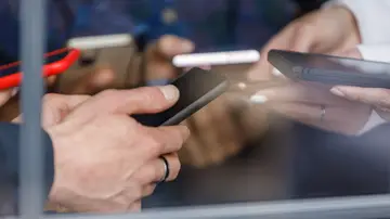 Jóvenes haciendo gestiones bancarias con el móvil Jóvenes haciendo gestiones bancarias con el móvil