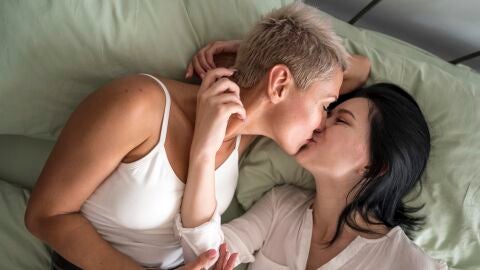 Una pareja se besa en la cama