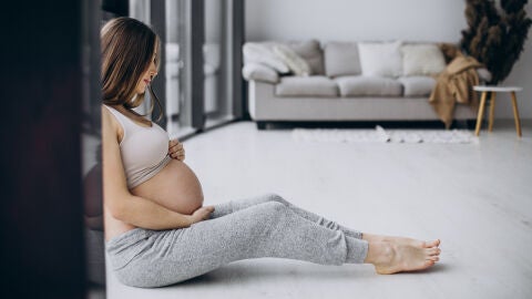 Mujer embarazada mirándose los pies