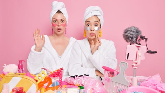 Mujeres con muchps productos de belleza para el cuidado facial