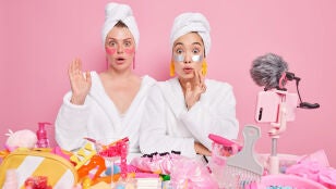 Mujeres con muchps productos de belleza para el cuidado facial