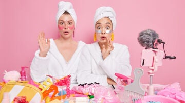 Mujeres con muchps productos de belleza para el cuidado facial