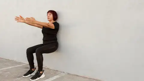 Una mujer haciendo ejercicios isométricos Una mujer haciendo ejercicios isométricos