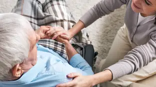 Una mujer cuida de un hombre en silla de ruedas Una mujer cuida de un hombre en silla de ruedas