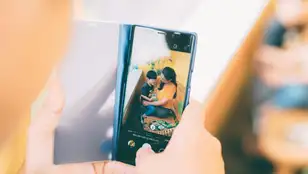 Imagen de una persona haciendo fotos a su hijo.