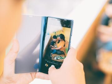 Imagen de una persona haciendo fotos a su hijo.