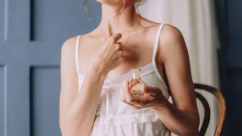 Mujer usando perfume Mujer usando perfume