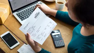 Una mujer consulta el cargo de un recibo