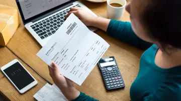 Una mujer consulta el cargo de un recibo Una mujer consulta el cargo de un recibo