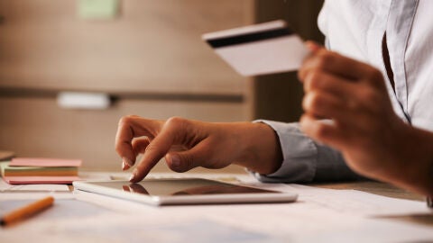 Una mujer con una tarjeta de crédito y una tablet