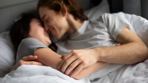 Pareja se abraza en la cama Pareja se abraza en la cama