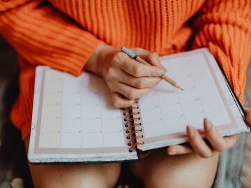 Una mujer apuntando en la agenda