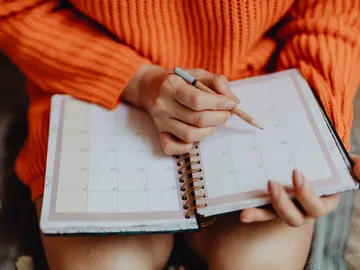 Una mujer apuntando en la agenda Una mujer apuntando en la agenda