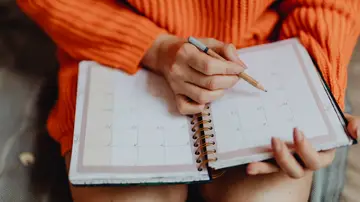 Una mujer apuntando en la agenda Una mujer apuntando en la agenda