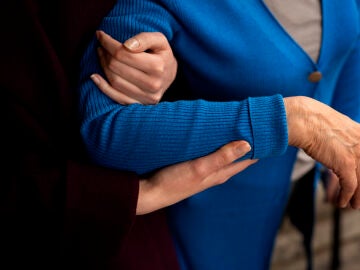 Unas manos que sostienen a una mujer mayor