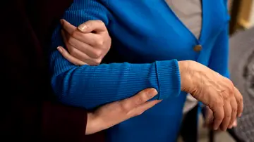 Unas manos que sostienen a una mujer mayor Unas manos que sostienen a una mujer mayor