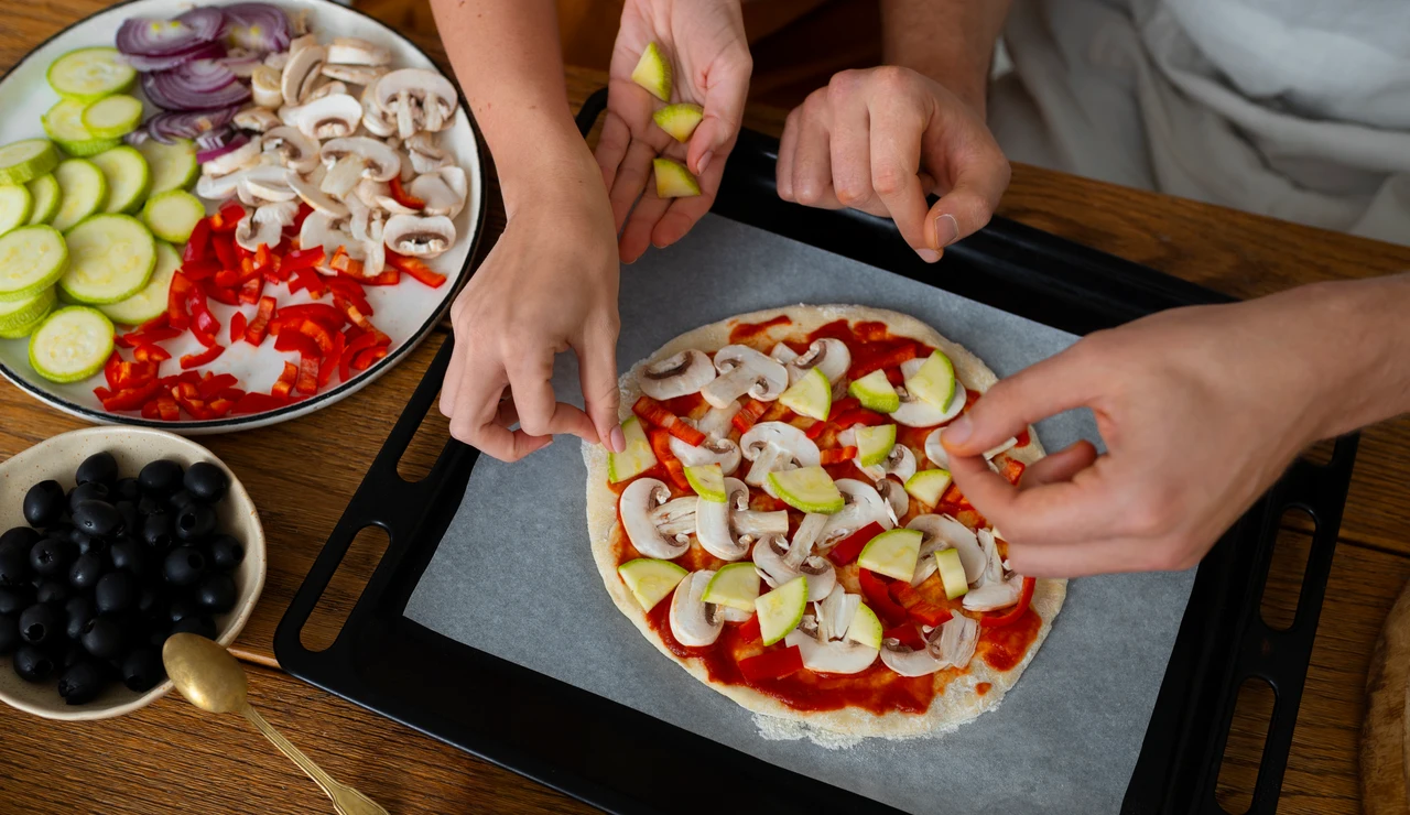Dos personas cocinando una pizza