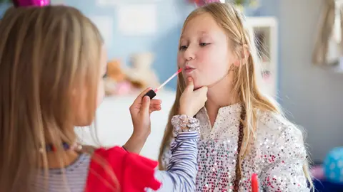Dos niñas juegan a maquillarse Dos niñas juegan a maquillarse