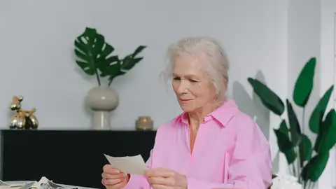 Imagen de archivo de una mujer mirando una fotografía Imagen de archivo de una mujer mirando una fotografía
