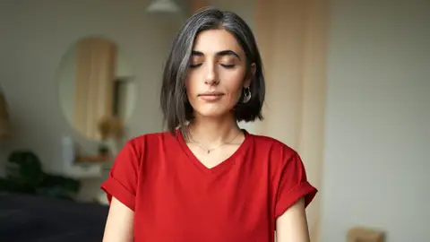 Mujer reflexionando con los ojos cerrados en casa Mujer reflexionando con los ojos cerrados en casa