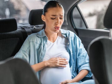 Mujer con contracciones de parto fuertes en el coche