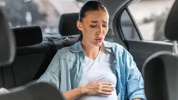 Mujer con contracciones de parto fuertes en el coche Mujer con contracciones de parto fuertes en el coche