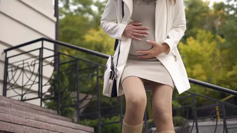 Una mujer con contracciones muy fuertes por la calle Una mujer con contracciones muy fuertes por la calle