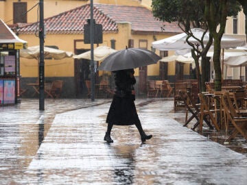 Imagen de archivo de una mujer caminando bajo la lluvia en La Laguna