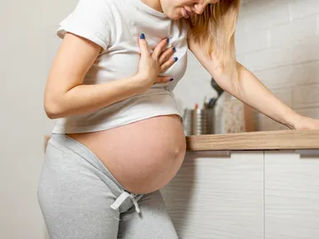 Una mujer embarazada con náuseas Una mujer embarazada con náuseas