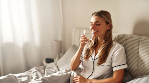 Mujer con un vaso recién despertada