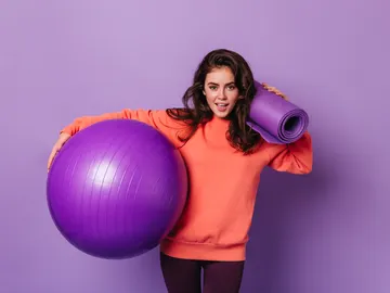 Una mujer con una fitball preparada para hacer ejercicio Una mujer con una fitball preparada para hacer ejercicio