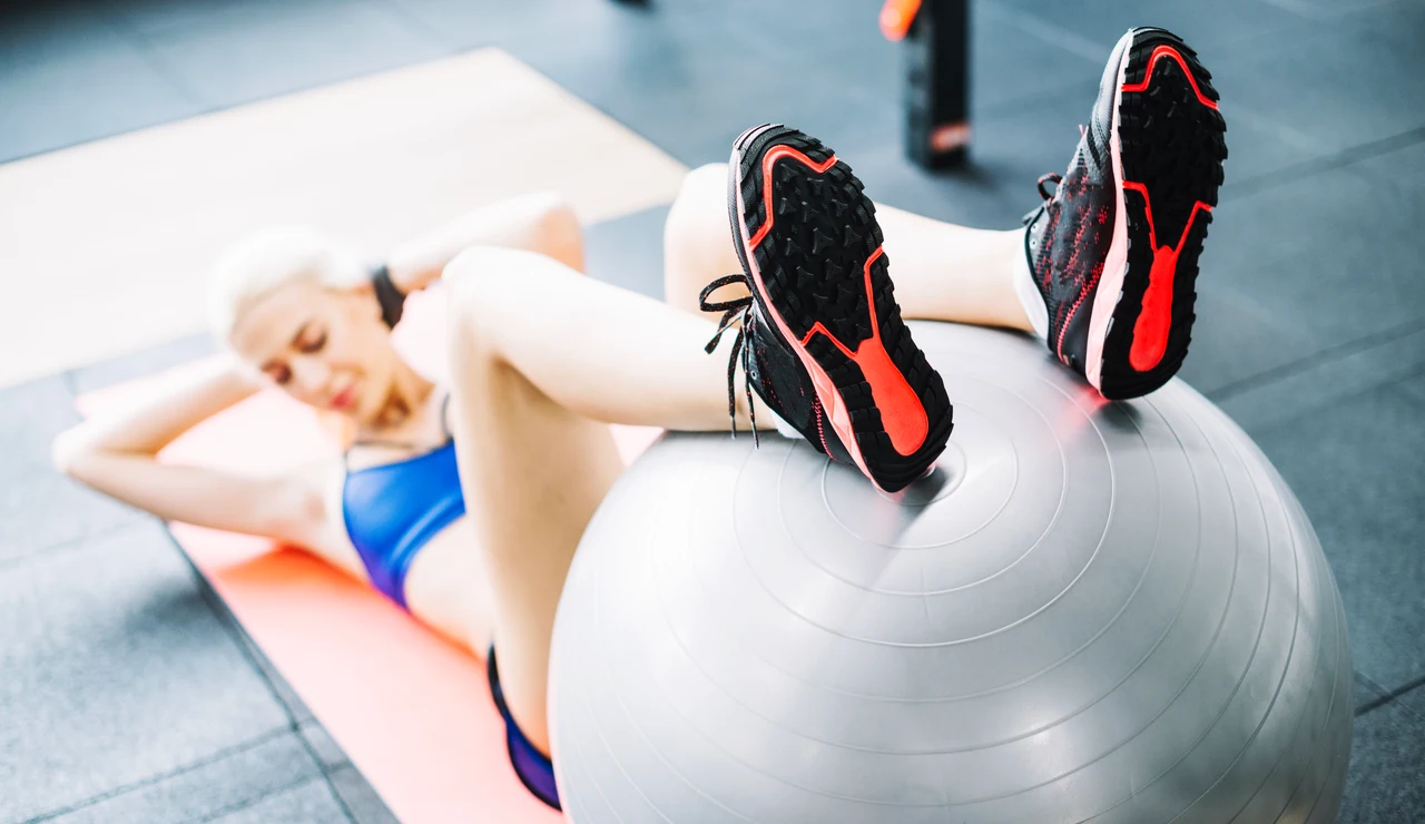 Una mujer realiza ejercicios con la fitball