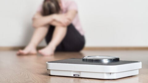 Mujer triste ante una báscula