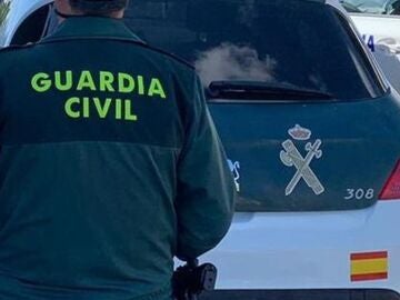 Imagen de archivo de un agente de la Guardia Civil junto a un vehículo oficial