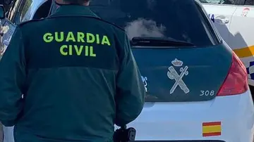 Imagen de archivo de un agente de la Guardia Civil junto a un vehículo oficial Imagen de archivo de un agente de la Guardia Civil junto a un vehículo oficial