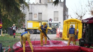 Varias personas de la UME desinfectan vehiculos, durante la presentaci&oacute;n de los medios de la UME para el control de la peste porcina