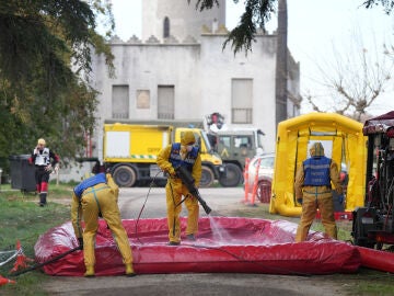 Varias personas de la UME desinfectan vehiculos, durante la presentación de los medios de la UME para el control de la peste porcina