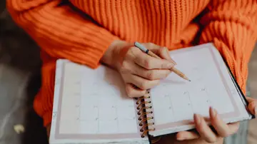 Mujer escribiendo en una agenda Mujer escribiendo en una agenda